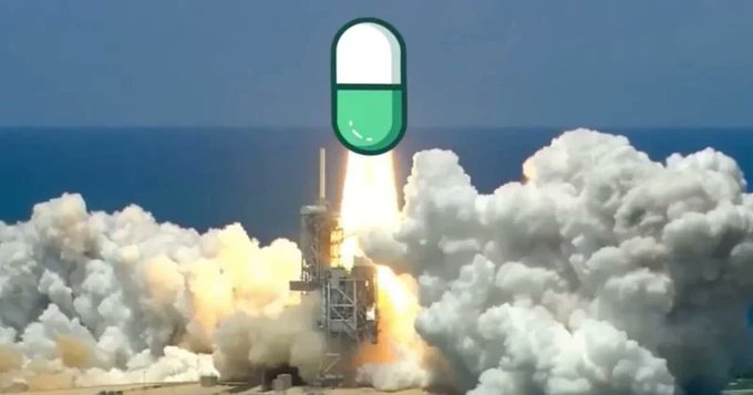 A rocket launch with massive white smoke clouds, overlaid with a green and white pill emoji at the top of the image.