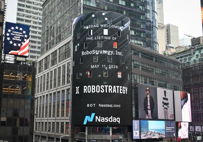 The Nasdaq tower displays "NASDAQ WELCOMES THE LISTING OF RoboStrategy, Inc." dated "MAY 11, 2026," featuring the ticker "BOT" and Nasdaq branding—marking the official listing event of the $BOT robotics fund that the post celebrates going live onchain via Solana.