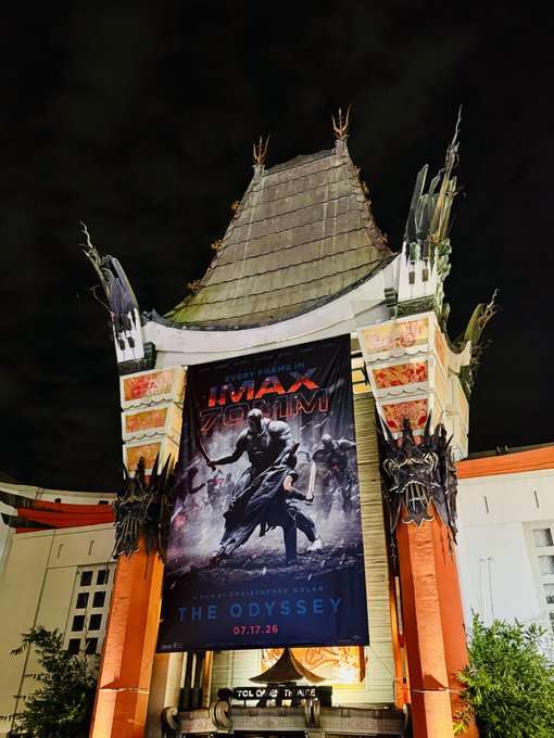 Nighttime photograph of the TCL Chinese Theatre marquee displaying a large poster for 'IMAX 70mm: The Odyssey' releasing 07.17.26.