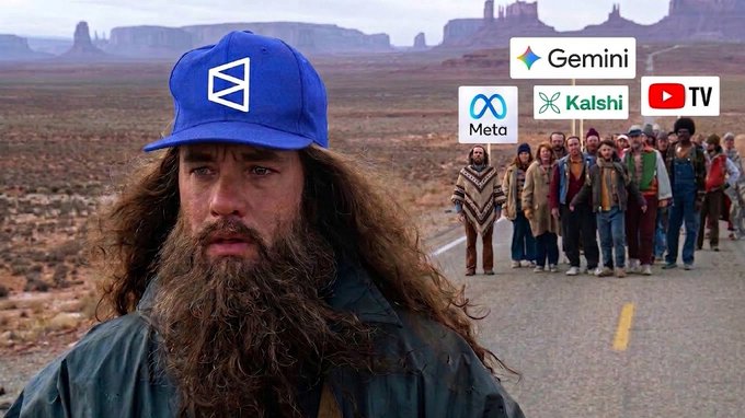 A man with long hair and beard wearing a Zcash (ZEC) blue cap in the foreground, with a group of people walking behind him on a desert road accompanied by logos for Gemini, Meta, Kalshi, and YouTube TV.