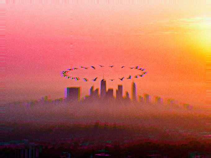 A flock of birds forms a circular pattern above a hazy city skyline silhouetted against a vibrant pink and orange sunset, with glitch-like distortions adding a surreal, digital aesthetic that complements the "Ritual Begins" NFT art theme.