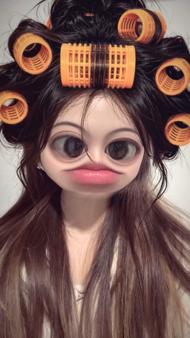A stylized AI-generated portrait shows a person with exaggerated large eyes and plump lips, their hair set in oversized orange plastic curlers. The image playfully illustrates the "hai semua" (Indonesian for "hi everyone") greeting, presenting a quirky, fun appearance as a way to say hello to followers.