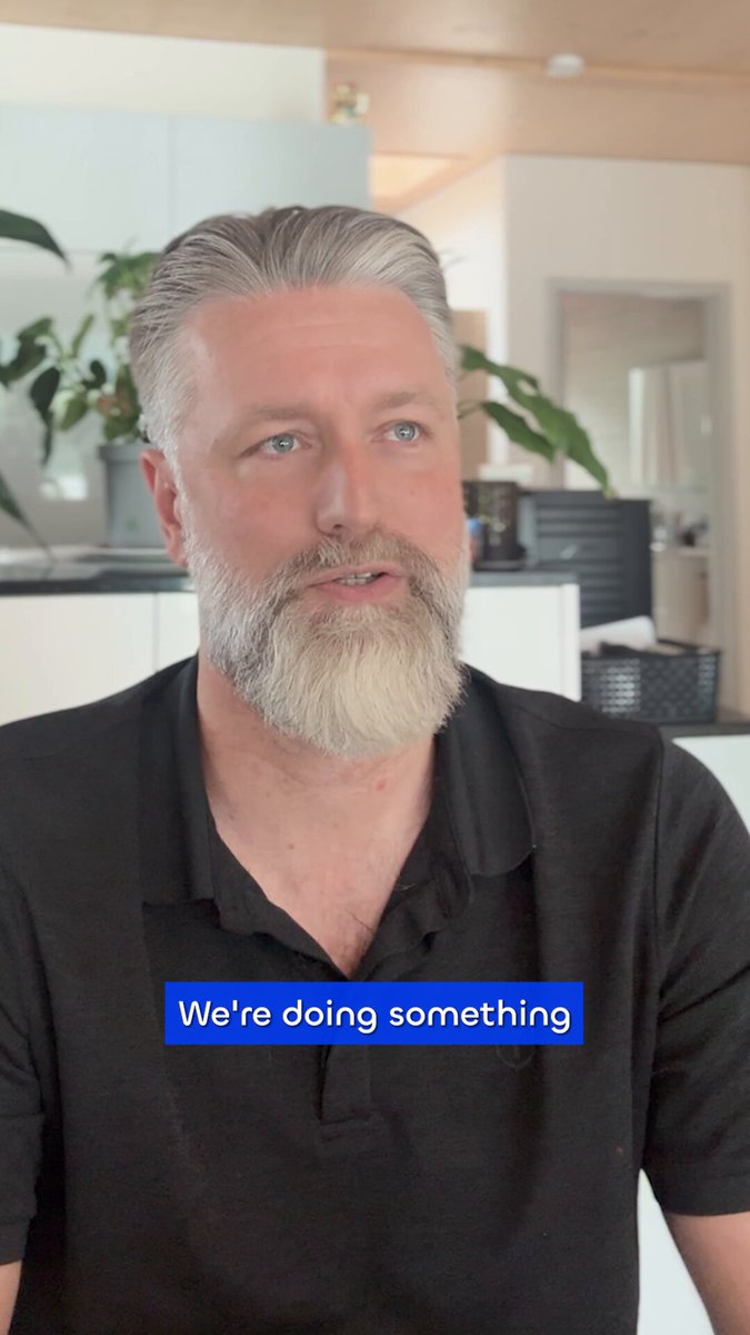The image shows a man with a beard wearing a black shirt, sitting down and looking at something off-camera. The caption of the image reads "We're doing something", which could be interpreted as a statement about the importance or relevance of the topic being discussed in the image.