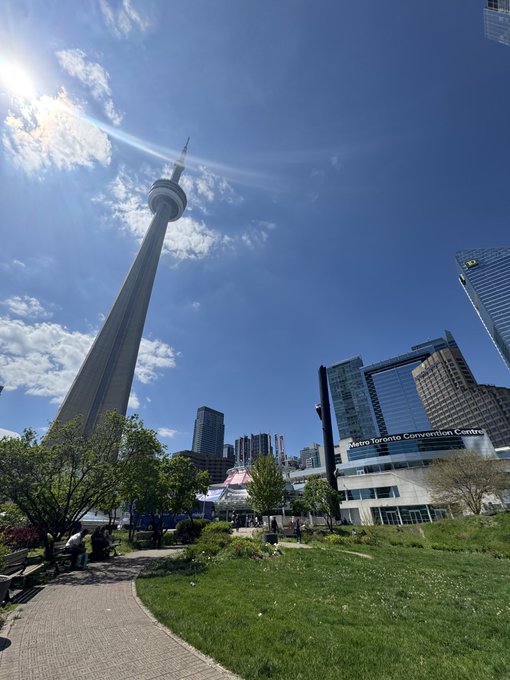The CN Tower rises above the Metro Toronto Convention Centre on a sunny day, confirming the Toronto location mentioned in the post about the Futurist Conference and the Doginal Dogs event at Rebel.