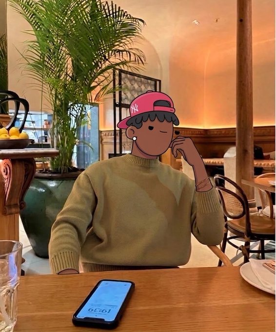 A person wearing a pink New York Yankees cap and beige sweater sits at a wooden cafe table with a smartphone displaying 12:59, while a cartoon illustration obscures their face.