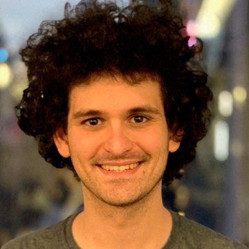 The image features a man with curly hair wearing a gray shirt who has a big smile on his face. The photo appears to be taken at night or during low light conditions, as there are some lights visible in the background that cast shadows around him. The caption reads "FTX founder Sam Bankman-Fried has reportedly formally applied for a pardon from President Trump. The timing is interesting, looking back, some of SBF's investments were extraordinary. Anthropic, SpaceX, Solana, Robinhood and Cursor have collectively generated tens of billions".