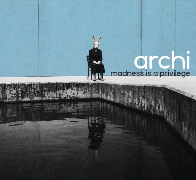 An album cover or artistic image featuring a figure wearing a rabbit mask and a black suit sitting on a chair beside a pool of water, with the text 'archi - madness is a privilege'.