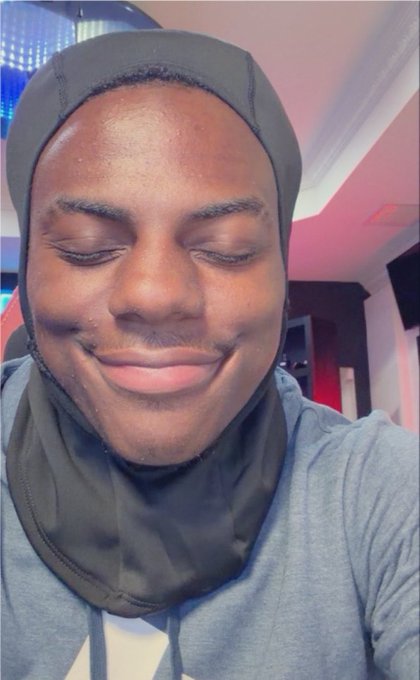 A young man wearing a dark durag and gray hoodie smiles with his eyes closed in what appears to be a recording studio, capturing a moment of quiet confidence. The image visually complements the post's theme of hopeful crypto anticipation, suggesting the creator's playful optimism that a $1M fortune awaits within one of his 40+ wallets.