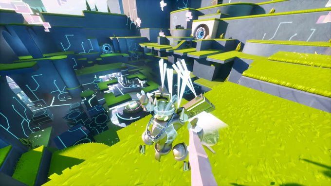 A screenshot from a video game showing a robotic, white and green character with long antennae standing on a bright green grassy ledge, with a futuristic, blocky environment in the background.