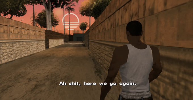 A screenshot from the video game Grand Theft Auto: San Andreas showing a character in a white tank top walking down an alleyway at sunset with the iconic subtitle 'Ah shit, here we go again.'