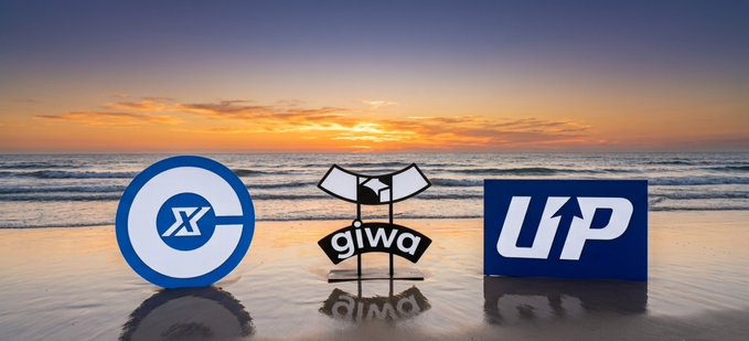 Three logos (Giwa, an 'X' coin logo, and 'UP') displayed against a sunset beach backdrop.