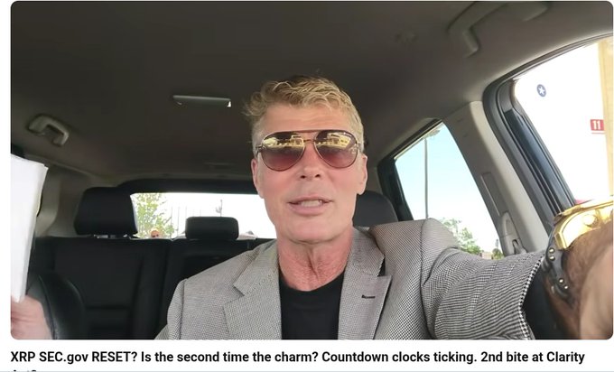 A man wearing aviator sunglasses, a gray blazer, and a black shirt sits in a car, with a caption reading 'XRP SEC.gov RESET? Is the second time the charm? Countdown clocks ticking. 2nd bite at Clarity'.