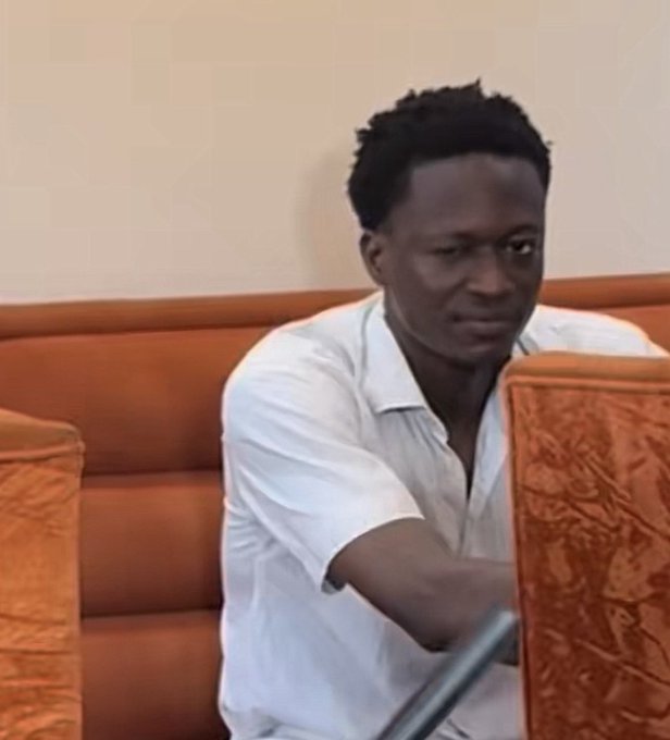 A man in a white shirt sits on an orange couch, focused intently on a screen while working on a laptop, reflecting the post's theme of cashing out winnings from a successful Polymarket bet on France.