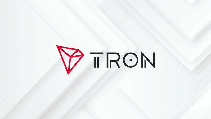 The TRON (TRX) cryptocurrency logo displayed in red and black on a white surface with geometric diagonal lines, showing the distinctive triangular diamond emblem next to the wordmark.