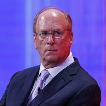 Larry Fink, CEO of BlackRock, the asset management giant whose ETF clients recently purchased $59.94 million worth of Ethereum ($ETH). The image shows him in a dark suit with a light purple tie, appearing focused during what looks like a panel or speaking engagement.
