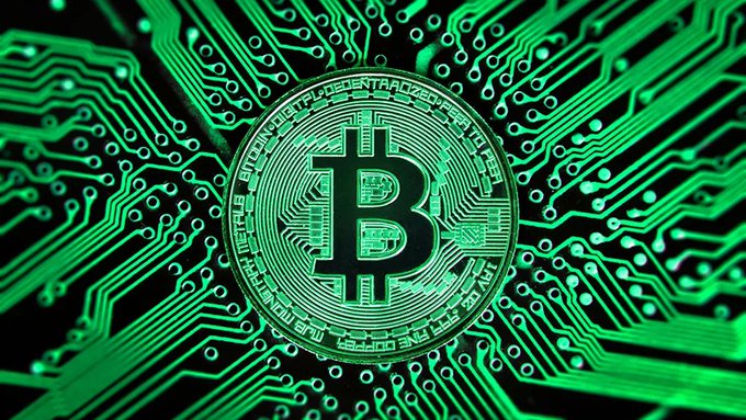 A Bitcoin coin is displayed against a glowing green circuit board background.