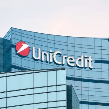 A photograph of a modern glass office building featuring the 'UniCredit' logo and its red and white emblem.