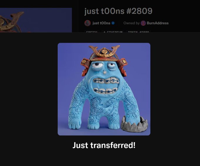 A screenshot showing a transfer notification for 'just t00ns #2809' NFT, featuring a blue cartoon monster wearing a samurai helmet, with the caption 'Just transferred!'.
