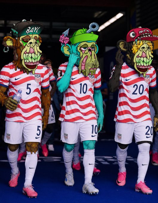 Three USA soccer players in red and white striped jerseys (numbers 5, 10, and 20) with cartoonish, grotesque monster heads featuring green skin, fangs, and exaggerated features, walking out of a stadium tunnel.