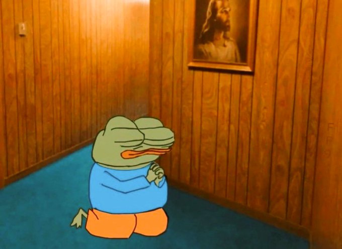 An animated scene of a green cartoon frog wearing a blue shirt and orange pants, kneeling on a blue carpet in a wood-paneled room and clasping its hands in prayer before a framed portrait of Jesus.