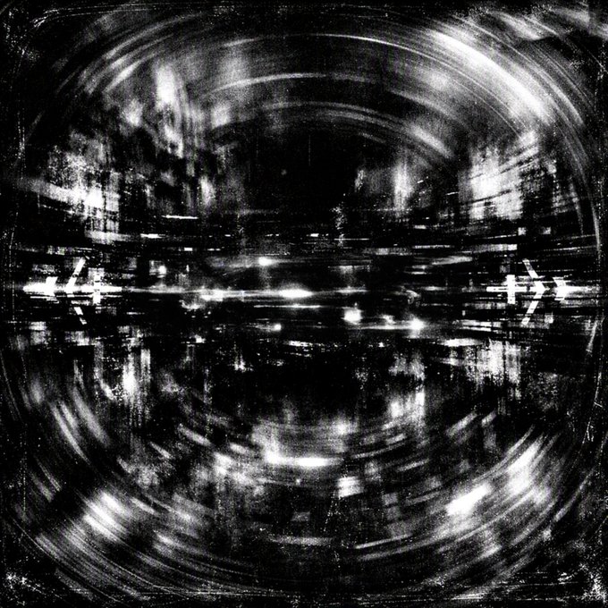 An abstract black-and-white image with blurred lights and motion lines creating a circular, tunnel-like pattern.