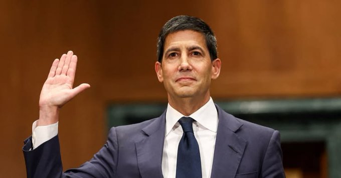 A man in a dark suit and tie is sworn in with his right hand raised in what appears to be a formal hearing setting. The image relates to the accompanying post about US economic data, as the man shown appears to be a Federal Reserve official whose testimony or statements on monetary policy would be highly relevant to discussions of PCE inflation and GDP growth figures.