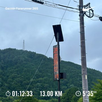 A Garmin Forerunner 265 screenshot showing a 13.00 KM run in 1:12:33 with a 5'35" pace, featuring a solar panel and electrical pole in the background.