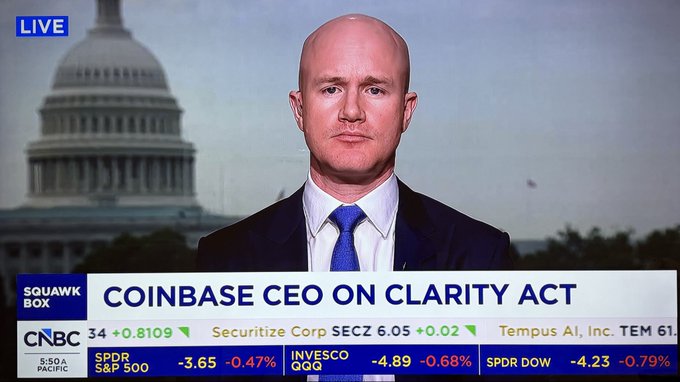 Coinbase CEO Brian Armstrong appears on CNBC's Squawk Box in a live broadcast with the U.S. Capitol in the background, discussing the Clarity Act. The on-screen ticker shows $COIN trading at $310.99 with related market data displayed. The image illustrates the breaking news moment when Armstrong expressed confidence that the Clarity Act would pass the Senate with 60+ votes.