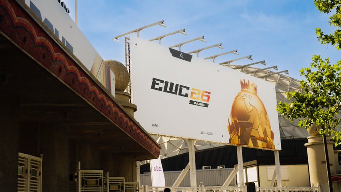A large billboard at what appears to be a stadium entrance advertises "EWC 25 PARIS" featuring a golden knight character, with event dates "PARIS JULY - AUGUST" displayed below.