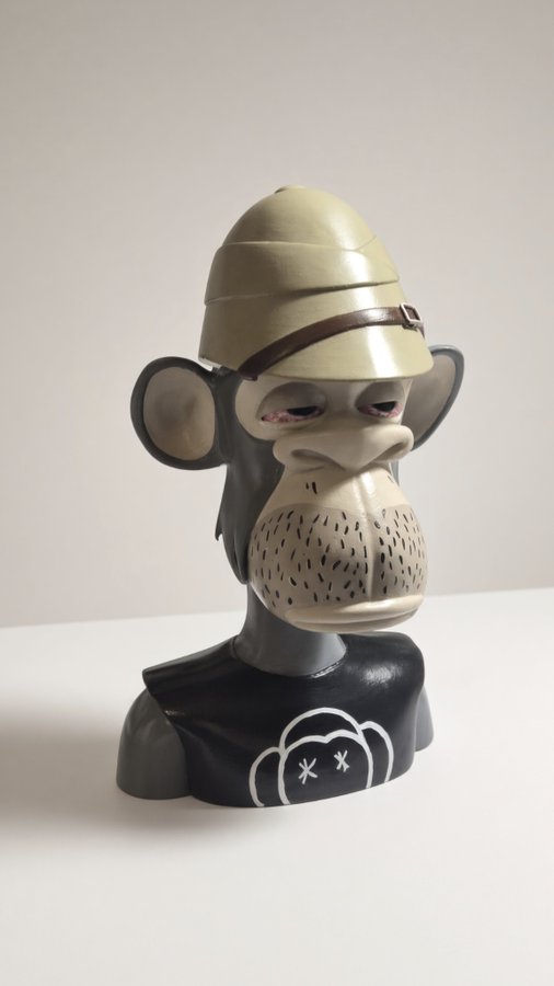 A sculpted bust of a stylized monkey character wearing a pith helmet, featuring detailed facial hair and a black shirt with a small cloud logo.