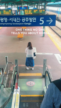 The image shows a person standing at a train station platform in Korea, with a sign indicating platforms 5 going toward "Gongmyeong-Seodaemun-Gongju" stations. There is no direct connection between the photo and a "Binance Liquidation Alert," as the post's caption does not match the visual content of a traveler at a Korean transit station.