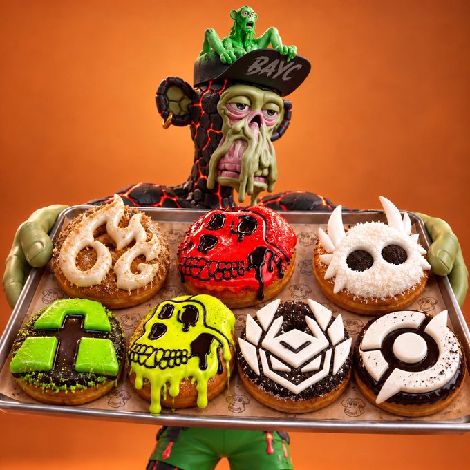 A Halloween-themed display features a figure holding a tray of six elaborately decorated donuts representing various video game logos and characters, including what appears to be World of Warcraft's Horde symbol, a red skull, World of Warcraft's Alliance symbol, Minecraft, Halo, and Pac-Man.