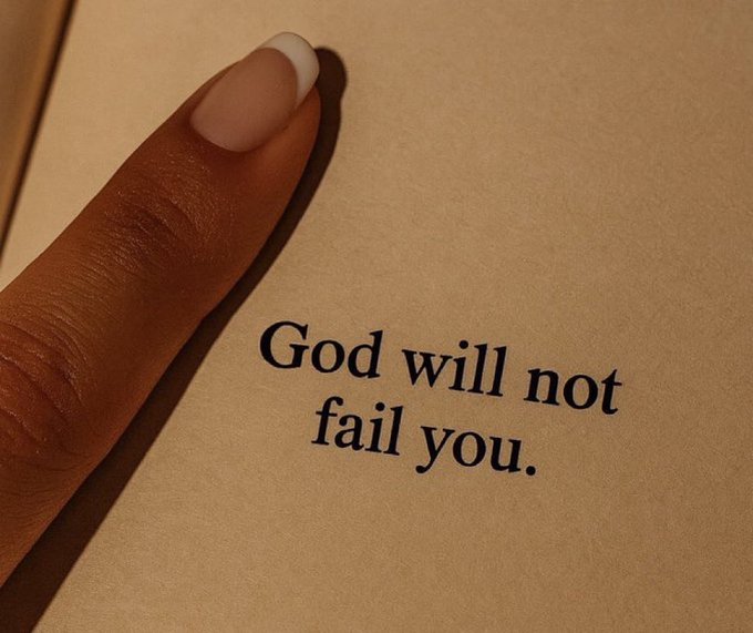 A close-up of a finger pointing to a page in a book that reads 'God will not fail you.'