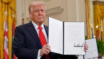 Former President Donald Trump holds up a document, his signature visible. This image is used to symbolize the potential signing of the "Bitcoin Clarity Act," a major crypto bill that the accompanying post suggests could become law soon.