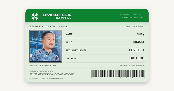 A green 'UMBRELLA CAPITAL' security identification badge for 'huey' in the Biotech Division, marked as 'LEVEL 01' with ID 003564 and a registration signature.