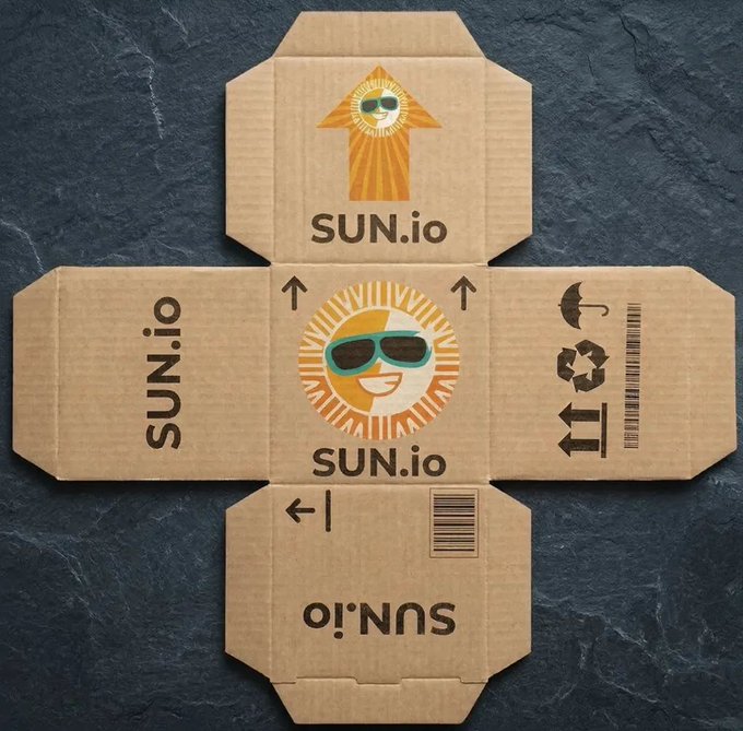 A flattened cardboard box layout for "SUN.io" featuring an orange sun mascot wearing sunglasses, displayed on a dark slate background. The image visually reinforces the post's theme by presenting the SUN.io brand as a tangible, ready-to-deploy Web3 product integrated with the TRON blockchain ecosystem.