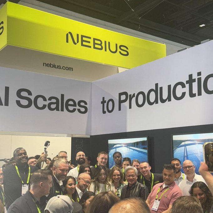 A crowd gathers at a brightly lit Nebius (ticker $NBIS) trade show booth, posing for a group photo beneath signage reading "AI Scales to Production" and the company's website "nebius.com." The bustling, well-attended booth and energetic team presence visually support the post's bullish sentiment, suggesting strong company momentum and visibility.