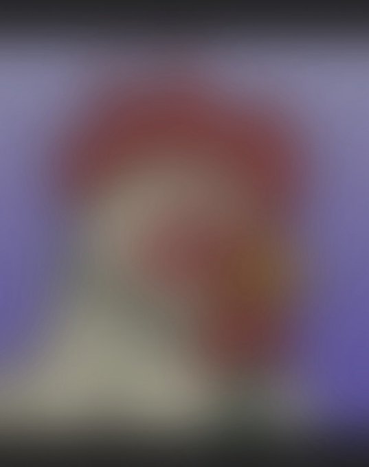 A heavily blurred image showing indistinct purple, red, and beige tones, making the subject impossible to identify.