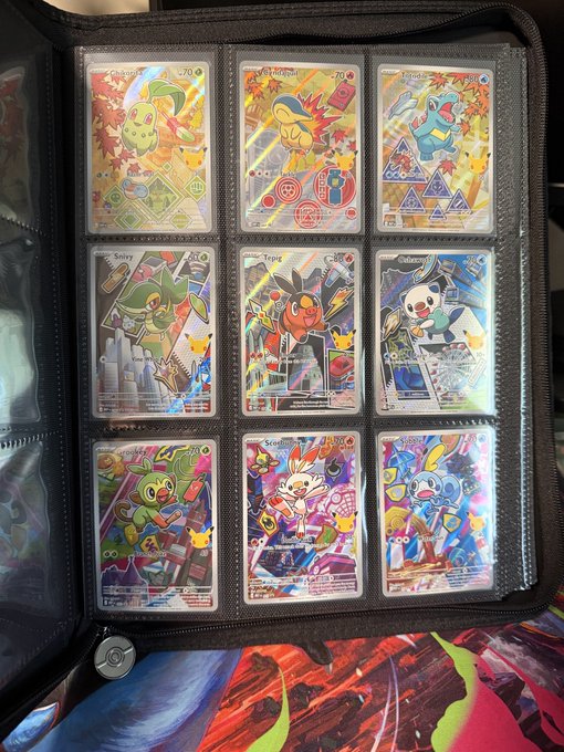 A black binder displaying nine colorful Pokémon trading cards in protective sleeves, including Sprigatito, Fezandipiti, and Quaquaval, arranged in a 3x3 grid.