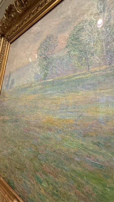 The image features an oil painting of a field with trees, which appears to be a landscape genre piece. The artist has used a variety of colors for the trees, including green, brown, and yellow hues. The painting is framed by gold trim, adding an elegant touch to the artwork. The post reads "bros monet is a slop", which could possibly be a reference to the artist's name or a description of the painting style.