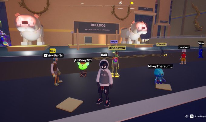 A screenshot of a virtual metaverse gathering featuring several avatars with usernames like 'Dinopawnz', 'Balt', and 'MikeyThereum_', set in a room with 'BULLDOG' signage and large inflatable bulldogs.
