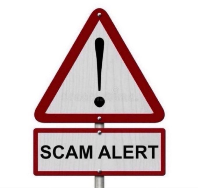 A red and white triangular warning sign with an exclamation mark and a rectangular plate below reading 'SCAM ALERT', commonly used to warn about fraudulent schemes.