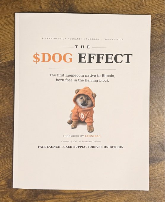 A book cover titled 'THE $DOG EFFECT' described as 'A CRYPTOLUTIONS RESEARCH HANDBOOK · 2026 EDITION' and 'The first memecoin native to Bitcoin, born free in the halving block,' featuring a Shiba Inu dog wearing an orange Bitcoin hoodie.
