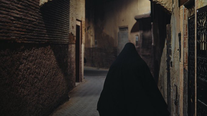 The image shows a person wearing a black robe walking down an alleyway, with a doorway visible behind them. The person appears to be shrouded in mystery as they move through the dimly lit space. The scene suggests that the individual might be a character from a science fiction story or a cyborg, given their futuristic attire and the way they navigate the alleyway.

The image also contains text that reads "Who's really behind zcash? the scientists (the brains): eli ben-sasson, alessandro chiesa, christina garman, matthew green, ian miers, eran tromer, madars virza., zooko wilcox (the cypherpunk". This text provides context to the scene and hints at a possible connection between the person in the image and the creators of the zcash cryptocurrency.