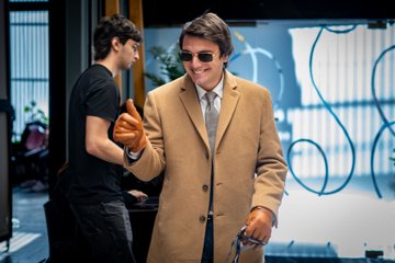 A man in a tan overcoat and sunglasses gives a thumbs-up alongside another man in a black t-shirt, likely capturing a moment from the Midnight Network hackathon in Buenos Aires that drew 87 hackers, including 59 newcomers to the ecosystem.
