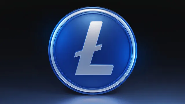 A glowing blue circular emblem features the Litecoin symbol (Ł) in silver at its center, set against a dark background. The polished coin-like design is illuminated with a bright blue light, highlighting the iconic "L" with a horizontal line through it that represents the Litecoin cryptocurrency.