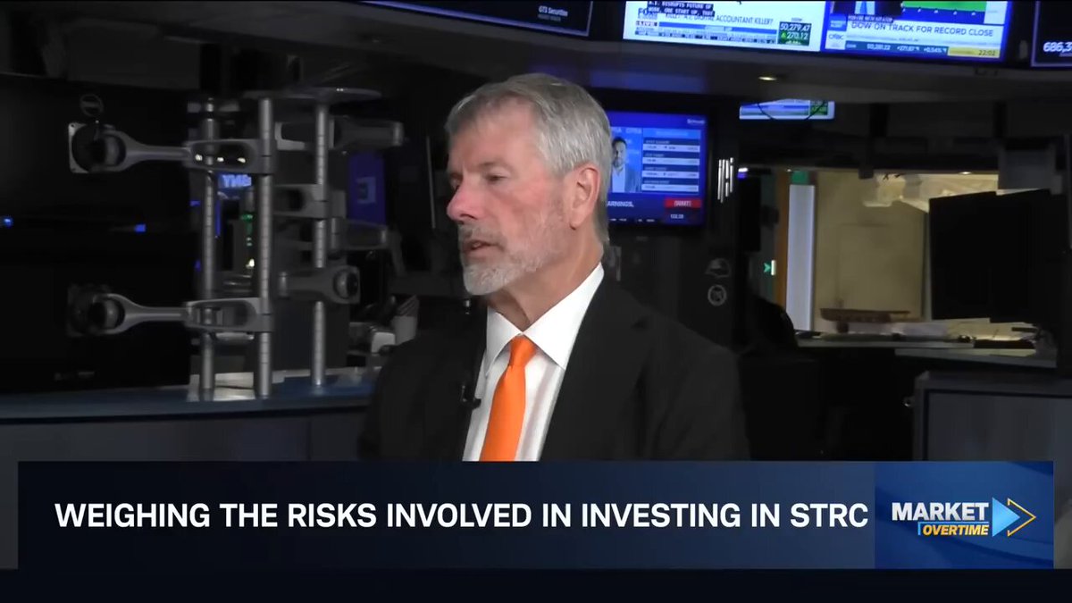 The image features a man wearing an orange tie, standing in front of a computer screen with a news article about investing in Stric.