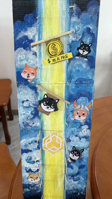 A decorated Longevity/Lucky Money envelope (li xi) painted with blue clouds and a yellow path features cartoon Shiba Inu dogs and cats, along with a gold 'MAME' coin and 'SHIB' logo.