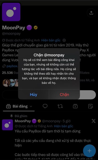 A screenshot of Twitter/X showing a block confirmation dialog for "@moonpay" overlaid on the MoonPay official account page, which displays a translated post in Vietnamese stating "Yêu cầu PayBox đã tạm thời bị tạm dừng" (PayBox requests have been temporarily suspended). The pop-up offers "Hủy" (Cancel) and "Chặn" (Block) options, suggesting the user was attempting to block MoonPay's account, possibly in frustration related to the post about issues with receiving payments from MoonPay.