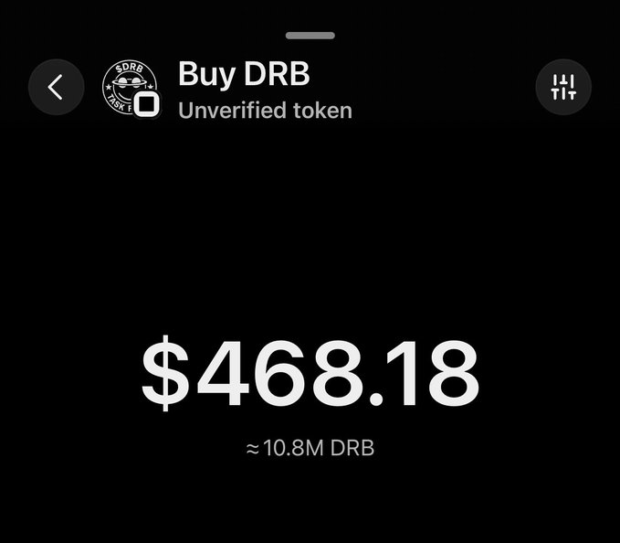 The image displays a black background with white text. The main focus of the image is a screen that shows the details of a transaction involving Bitcoin. It reads, "Buy $DRB Unverified token". Below this text, there's another piece of information about the transaction, stating that it took place on Monday and ended up at 10.8m DRB. This information suggests an online marketplace where people can buy and sell digital assets like cryptocurrency.